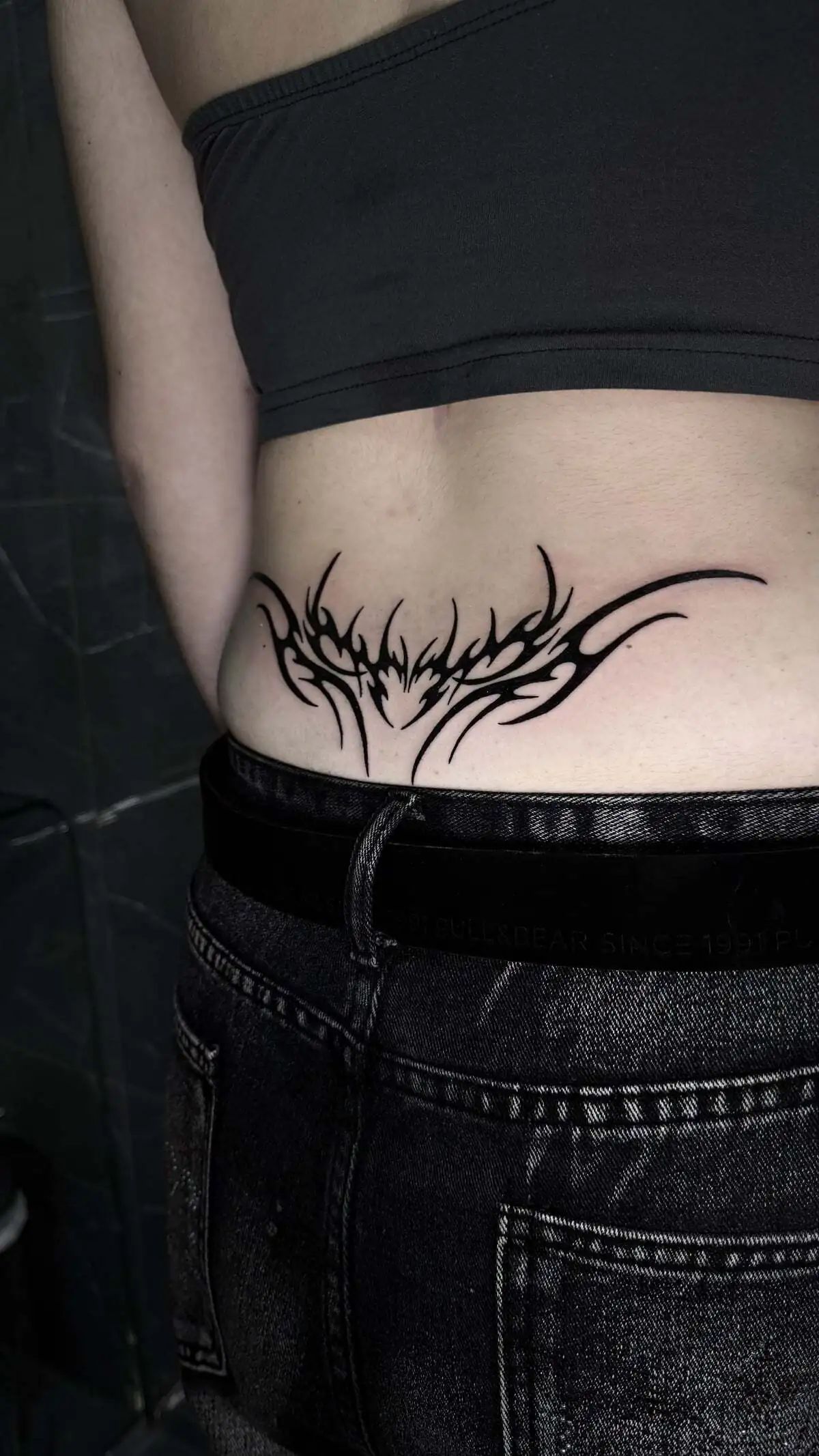 symmetrical tribal style lower back tattoo