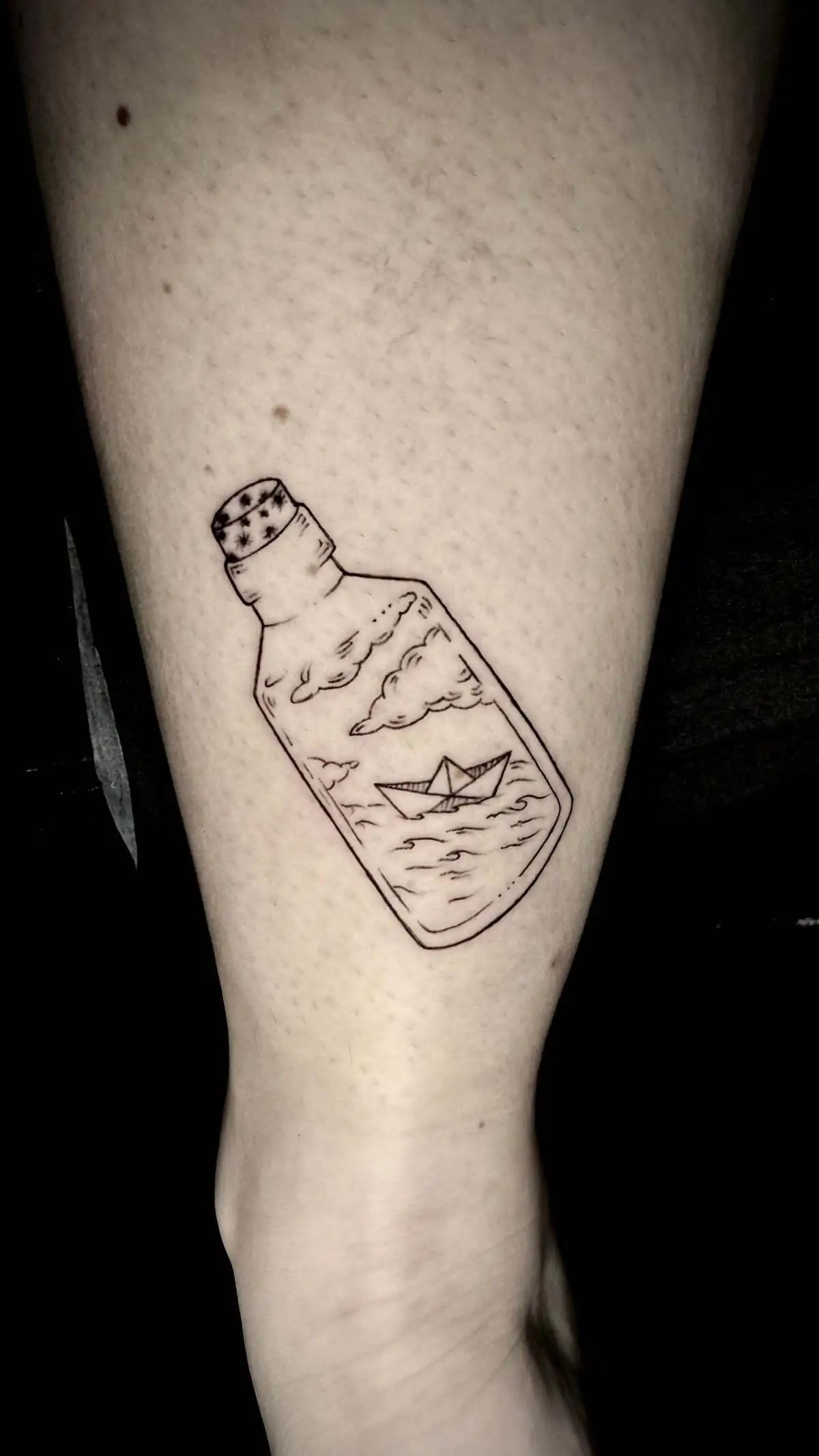 paper boat bottle fine line calf tattoo