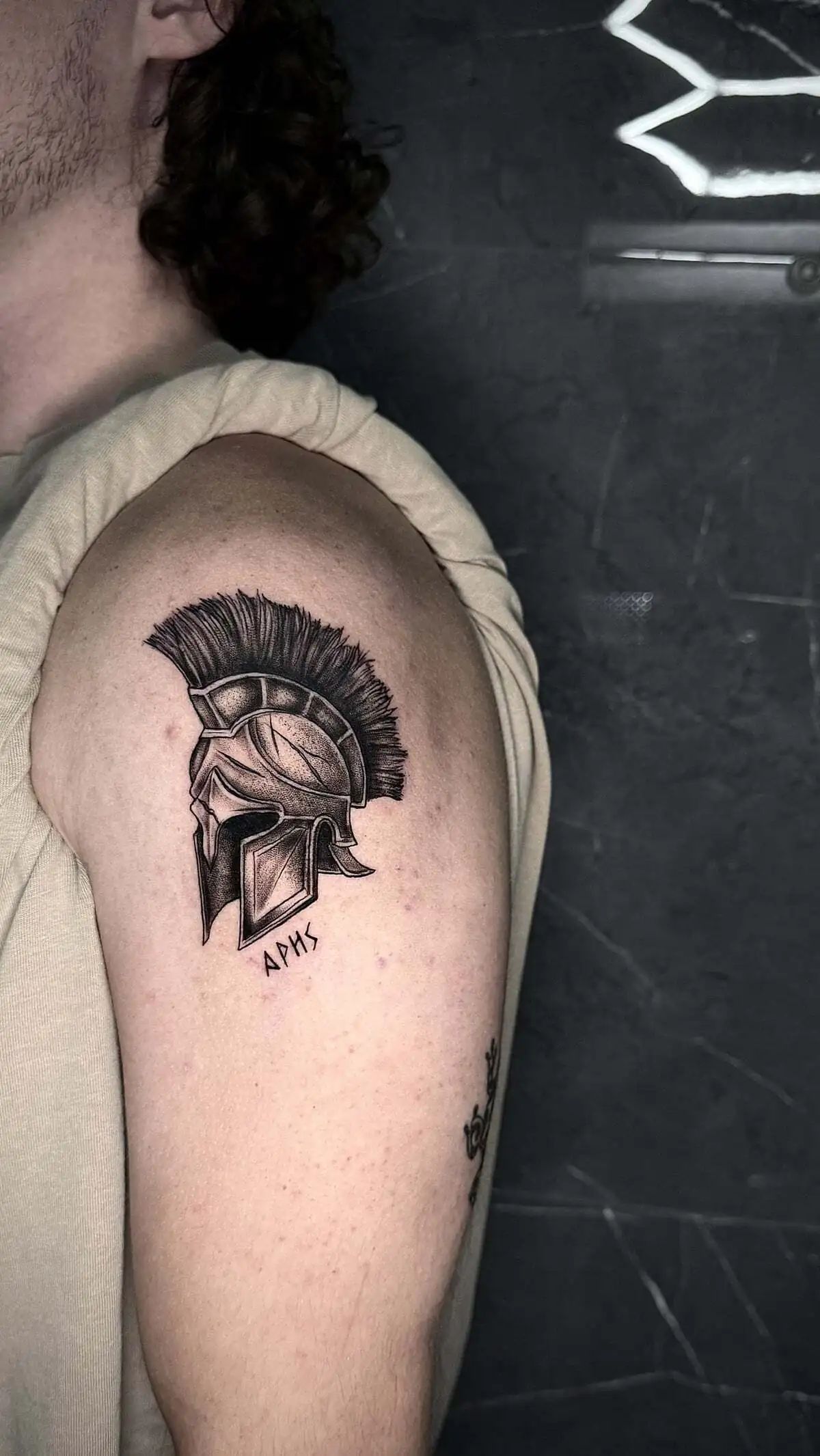 spartan helmet greek lettering micro realism shoulder tattoo