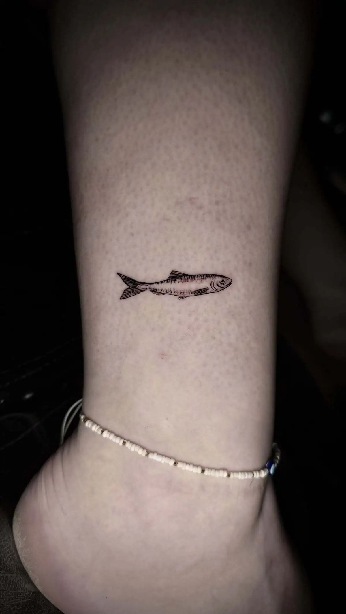 small realistic fish micro realism ankle tattoo