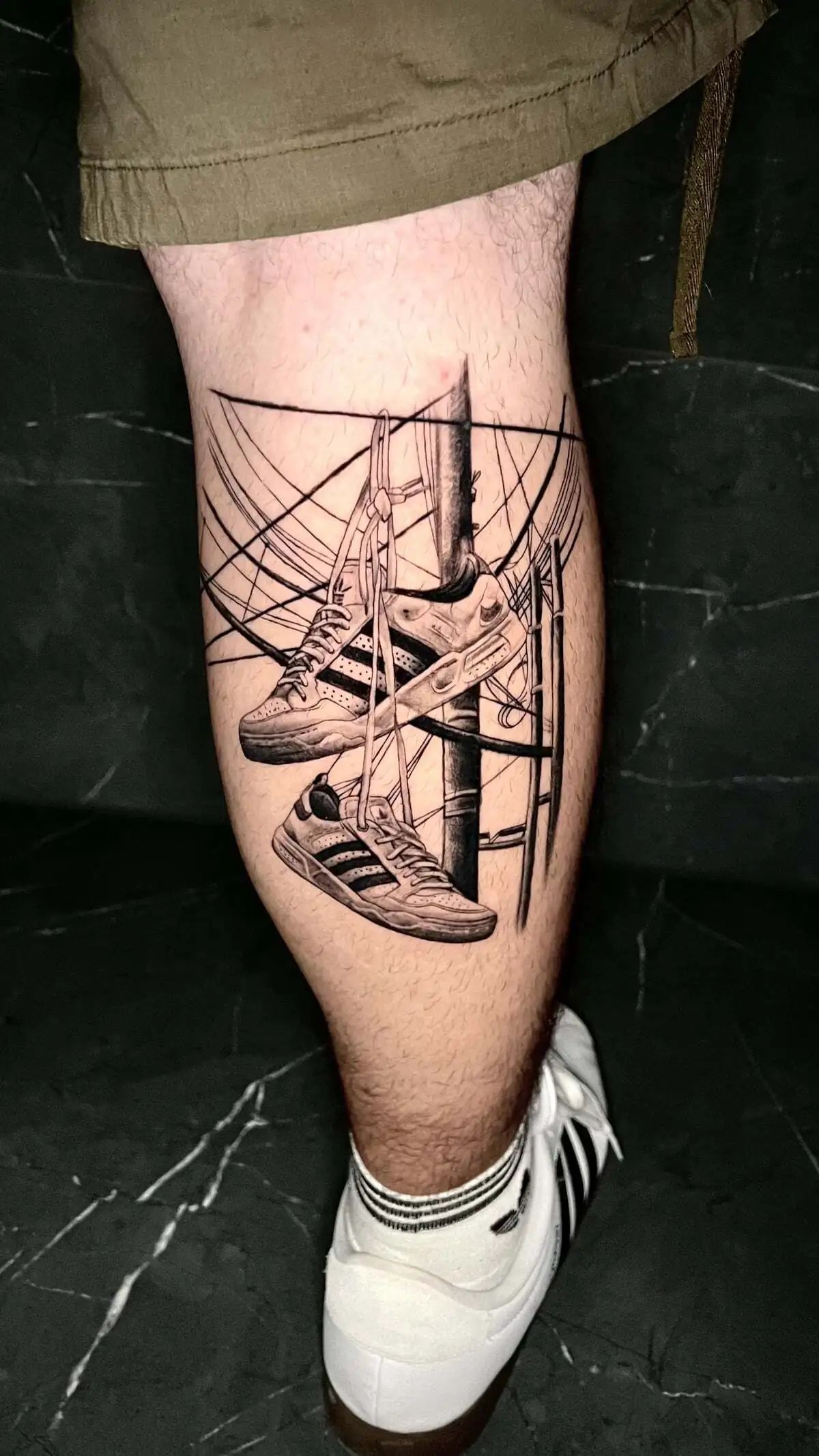 hanging sneakers street pole calf tattoo